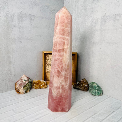 Frontal view of Rose Quartz Polished Tower, on a white surface.
