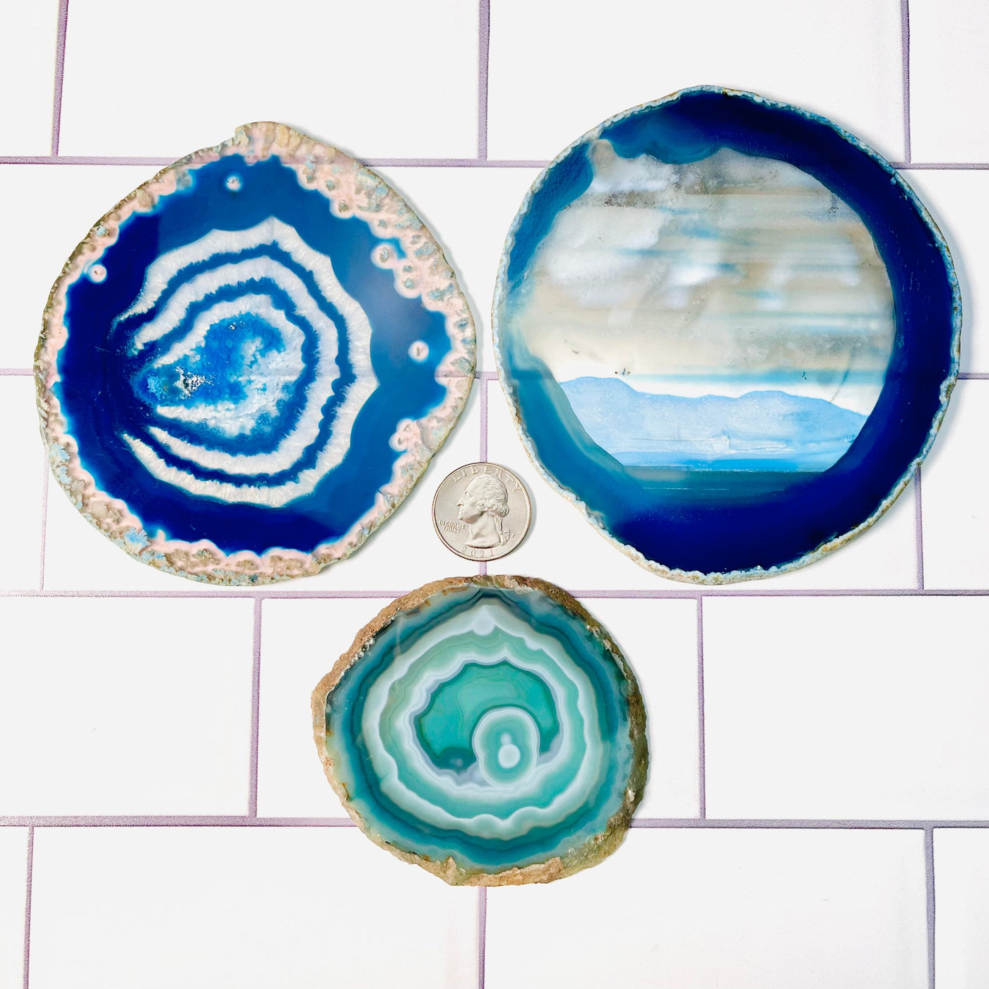 Set of 3 Agate Slices - Dyed Blue and Green, displayed on a tile surface. A quarter placed next to them as a size reference.