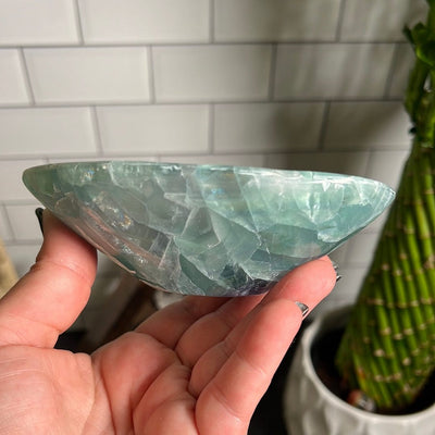 Small green fluorite bowl in a woman's hand.