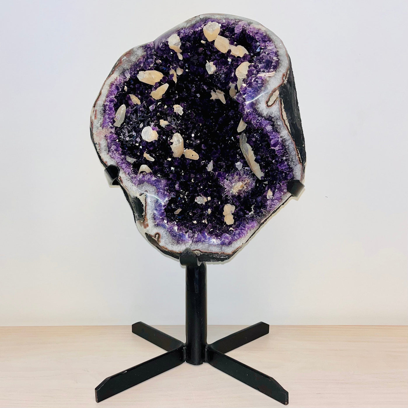 Frontal view of Large Dark Purple Amethyst and Calcite Geode on Metal Stand.
