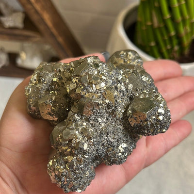 Pyrite with Hematite cluster in a woman's hand.