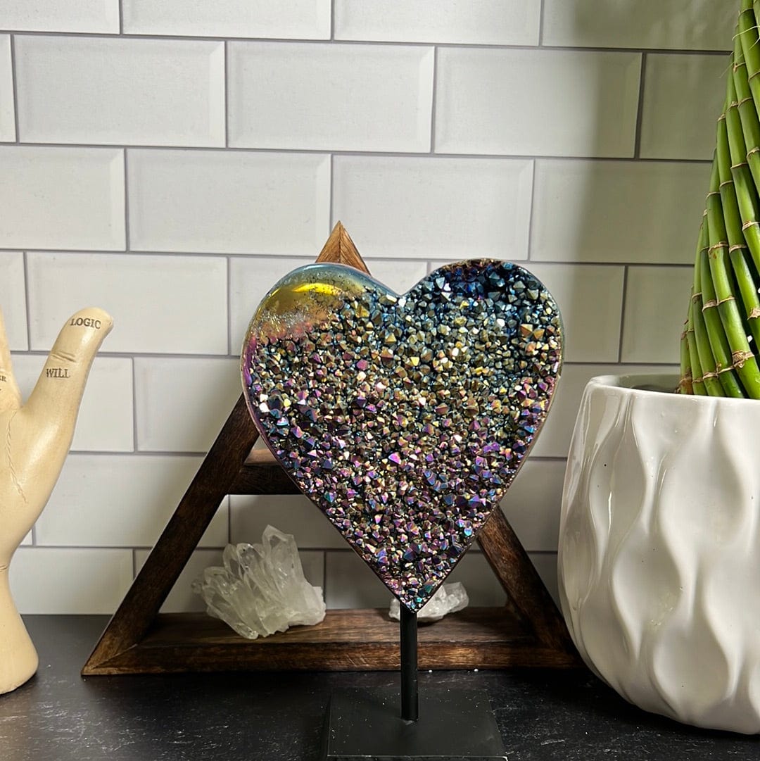 Amethyst Cluster heart that is coated with rainbow titanium on a black wood stand.