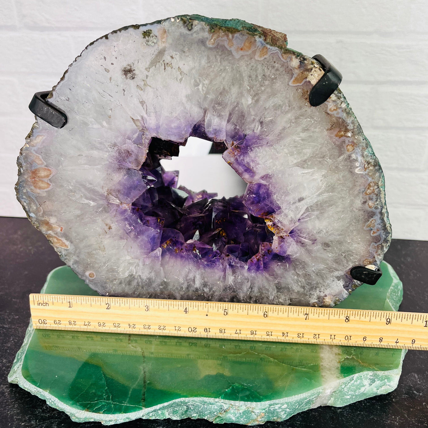 front  view of Amethyst Mirror mounted on wall pictured next to ruler