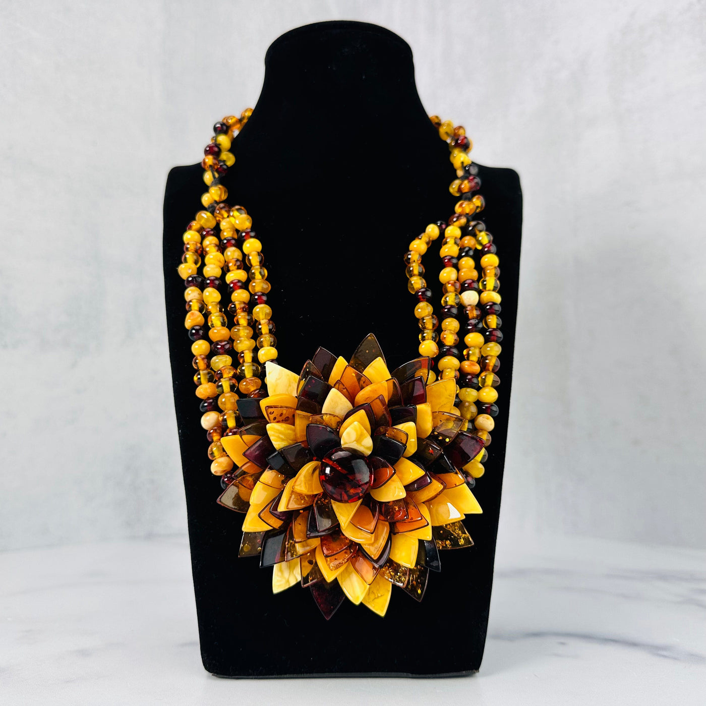 Frontal view of Multi-colored Baltic Amber Beaded Flower Necklace shown on a bust display.