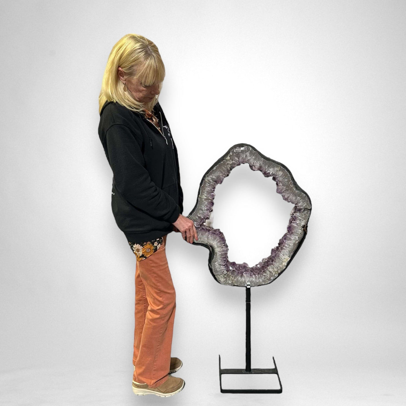 woman standing next to Large Amethyst Portal on Metal Stand on white background