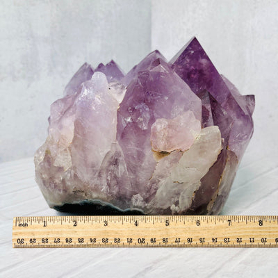 Side view of the Large Amethyst Point Cluster with a ruler next to it for size reference.