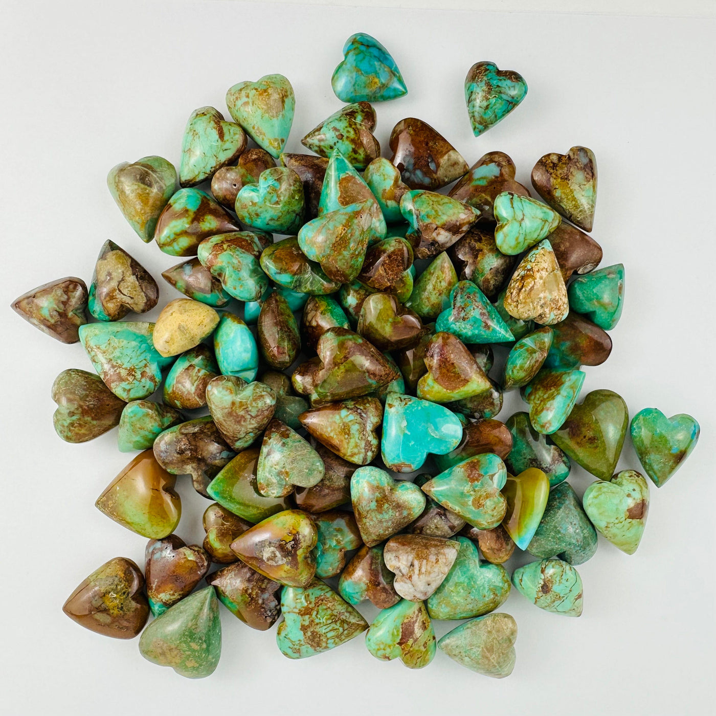 Turquoise Hearts  in a pile on a white table