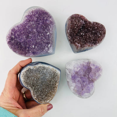 Amethyst Crystal Gemstone Hearts with a hand in the picture for size reference