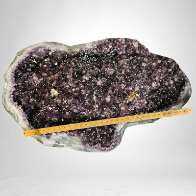 Amethyst Crystal Cluster Geode Table on Metal Base with a yard stick om top of it for size reference