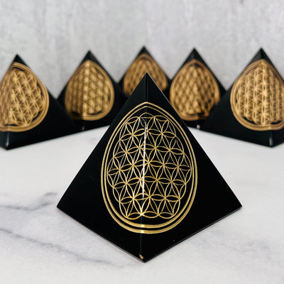 Frontal view of Black Obsidian Flower of Life Mini Pyramid, with multiple in the background.