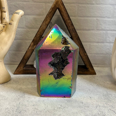 Rainbow titanium agate slice with a druzy center and some other openings on the stone.  It has some natural dent marks along the front.