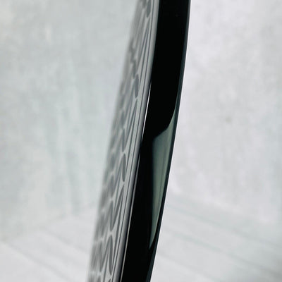 Up close side view of Black Obsidian Flower of Life Plate on a stand, displaying thickness of item.