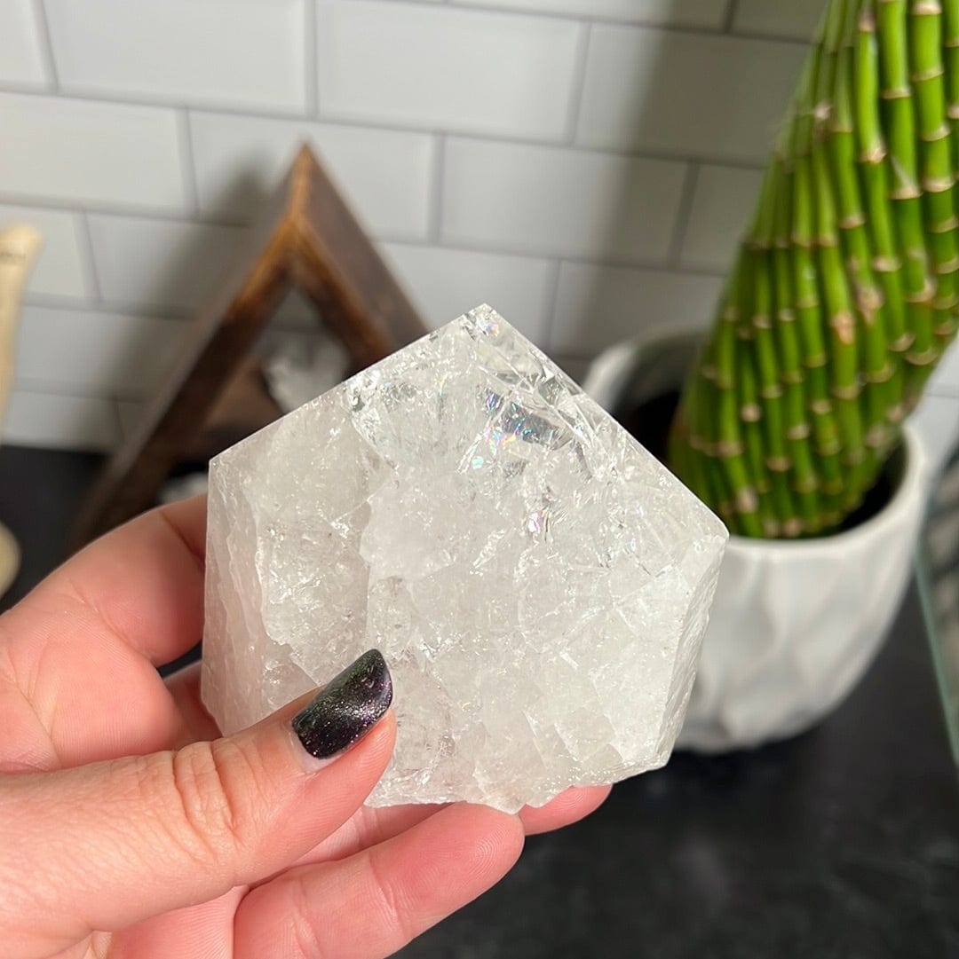 Crackle crystal quartz polished point held in a woman's hand.