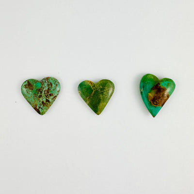 3 Turquoise Hearts Cabochon lined up next to each other on table