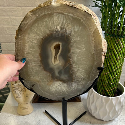 Agate slice on a black metal stand.