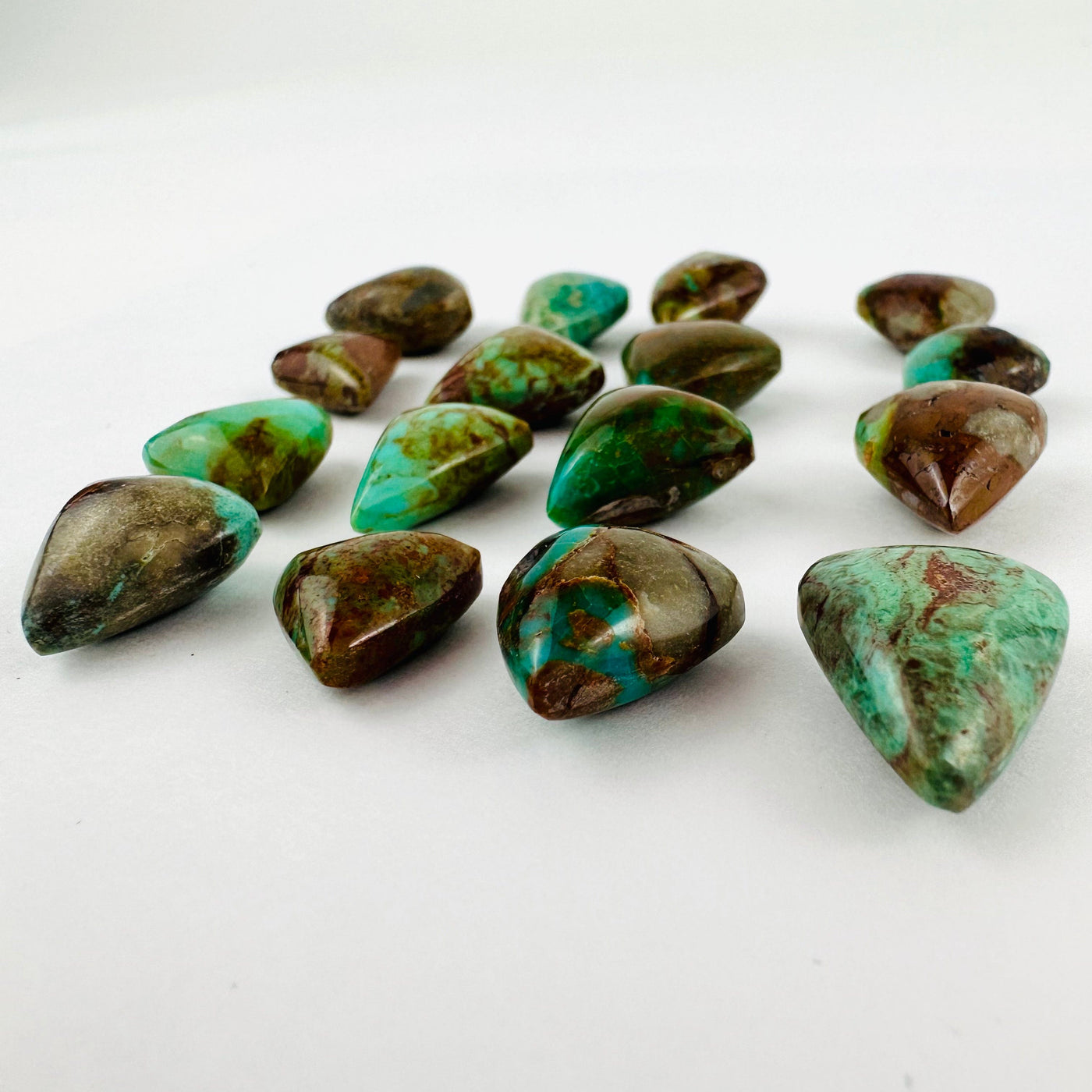 Side view of assorted turquoise hearts on a white background.