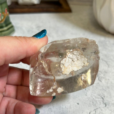 Lodolite seimi polished stone in a woman's hand.