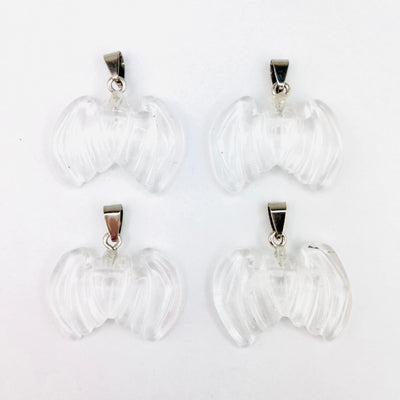 Four Clear Crystal Bat Gemstone Pendants displayed on a white surface.