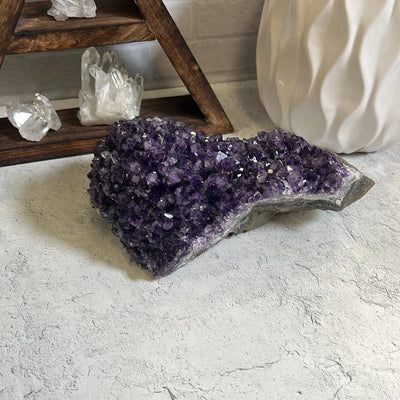 Large amethyst cluster formation on a gray background.