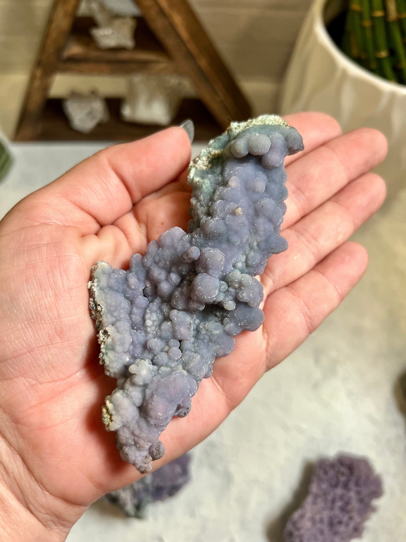 backside of Grape agate formation in a woman's hand.