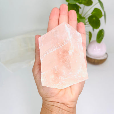 Pink Calcite Oblique Rectangular Prism pictured lying flat in palm of hand
