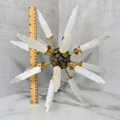 Selenite and Pyrite Spike Globe on a marble surface next to an upright ruler for size reference.