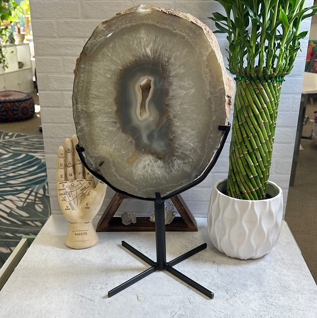 Agate slice on a black metal stand.