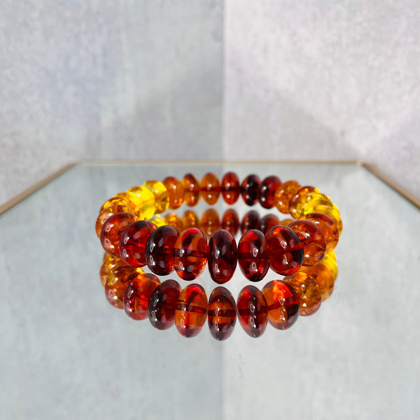 Up close view of Baltic Amber Bracelet on a mirrored surface.