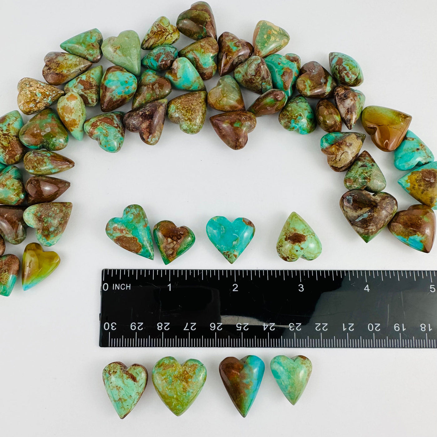 Turquoise Hearts next to a ruler for size reference