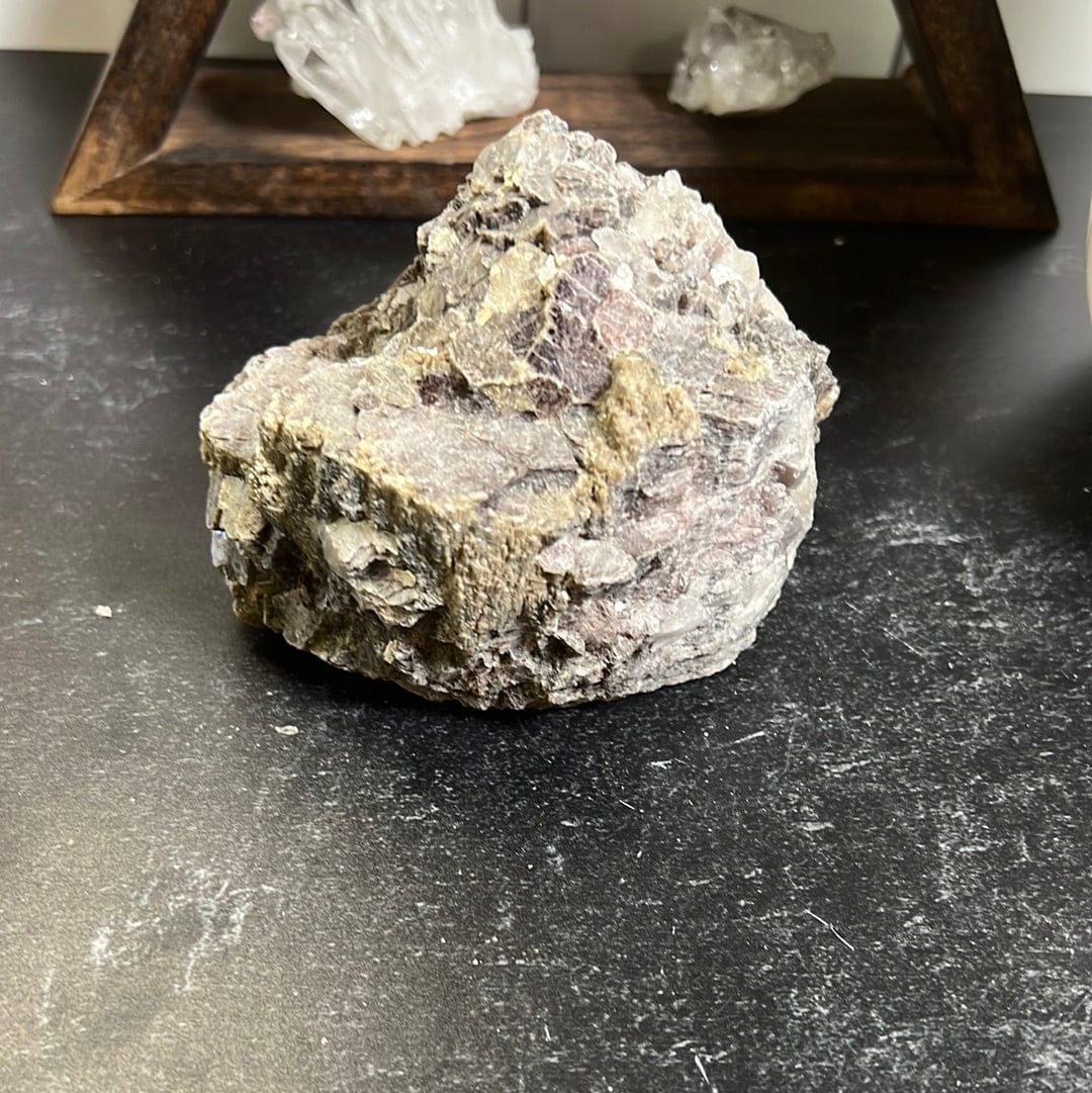 Lepidolite rough stone with golden mica scattered on it.