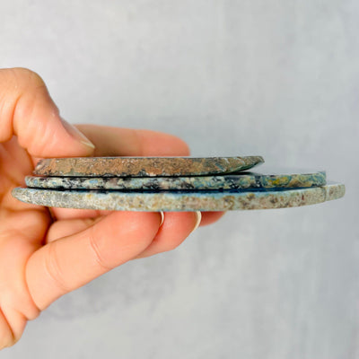 Side view of stacked Agate sliced, set of 3, held in woman's hand.