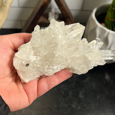 Crystal quartz cluster in a woman's hand.