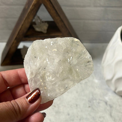 White amethyst flower cabochon held in a woman's hand.