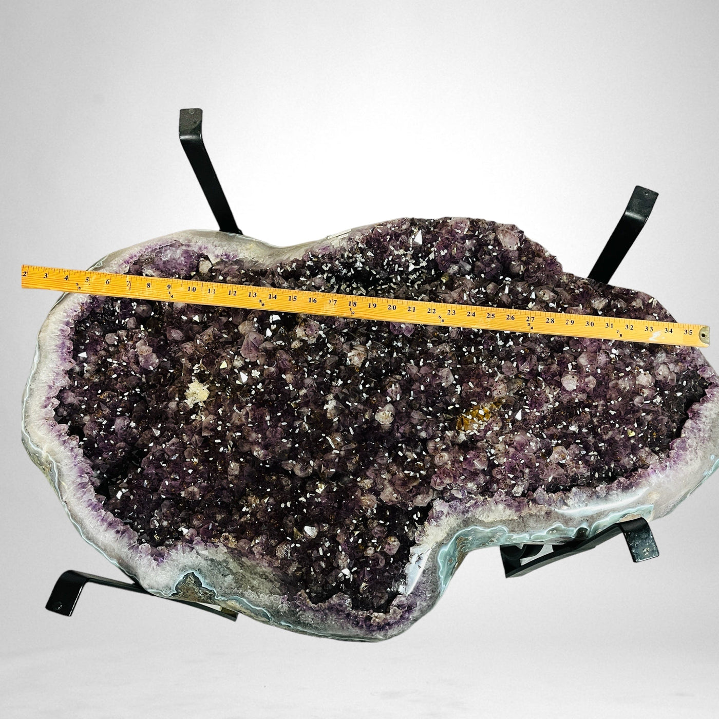 Amethyst Crystal Cluster Geode Table on Metal Base with a yard stick on top of it for size reference