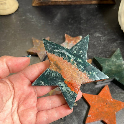 Green and red jasper star in a woman's hand.