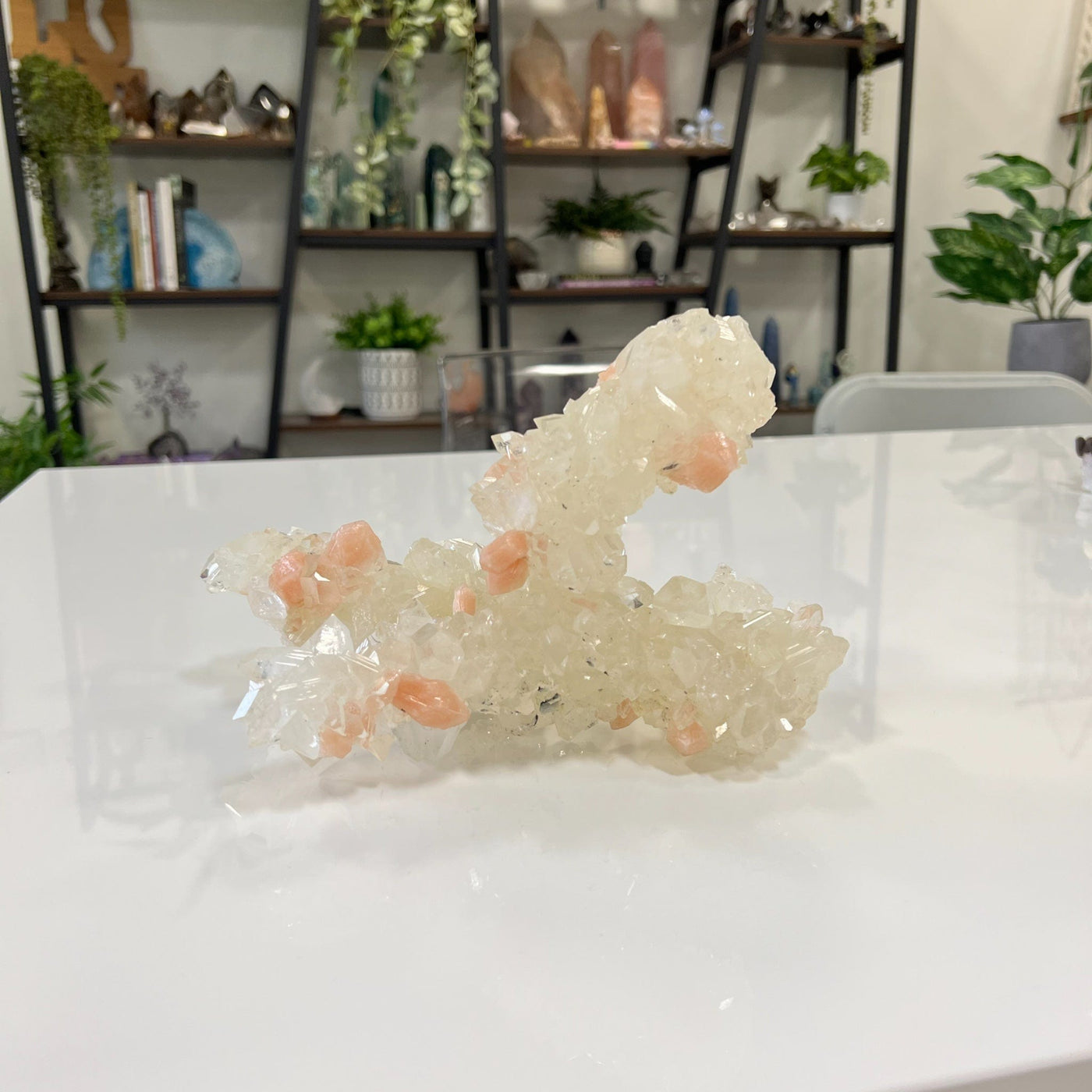 Apophyllite with Peach stilbite cluster on a white table.