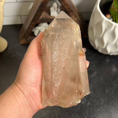 Large smokey quartz point in a woman's hand.