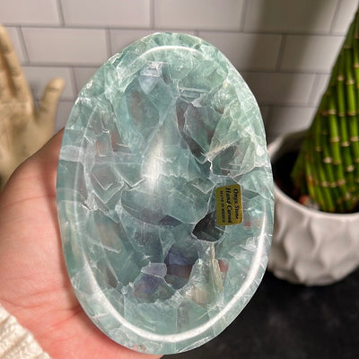 Small green fluorite bowl in a woman's hand.