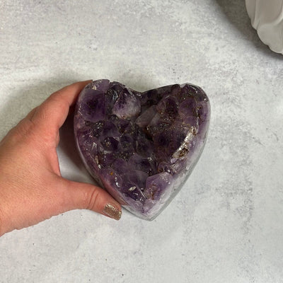 Large amethyst cluster heart purple with brownish orange spotting which is hematite or iron inclusions.