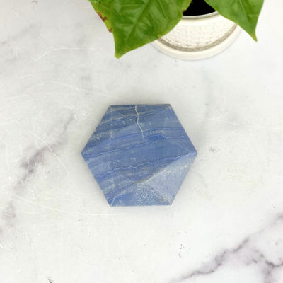 Blue Quartz Hexagon on marble background with plant