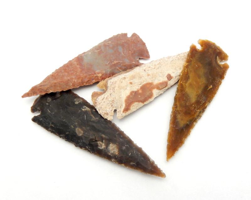Assorted  shades of Jasper arrowheads on a white background.  Pictured is cream with brown spots, dark brown, orange brown and a darker orange brown.