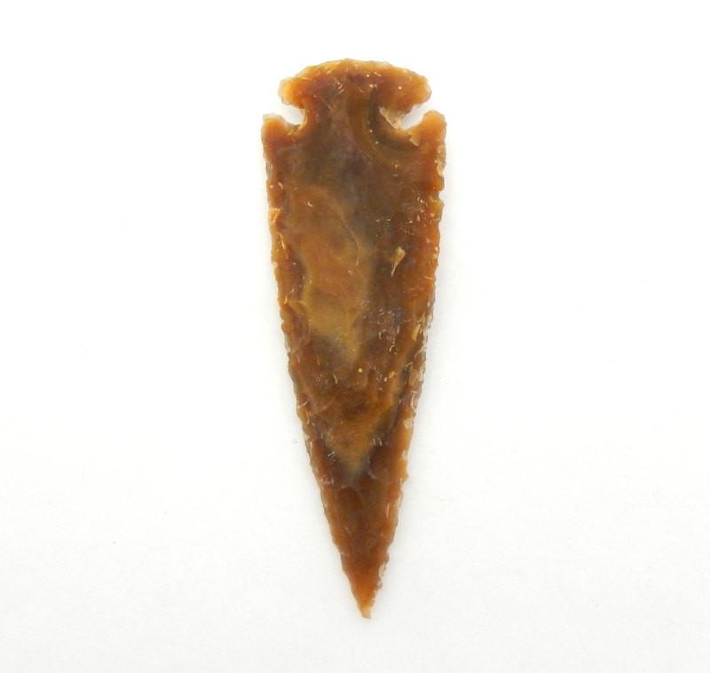 Close up of one orange brown jasper arrowhead on a white background