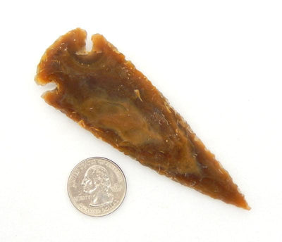Orange brown arrowhead with a quarter for comparison.  It is about 4 times the size of the quarter