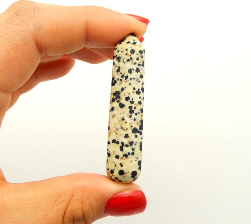 Dalmatian Jasper Massage Wand Points Gripped in fingers on White Background.