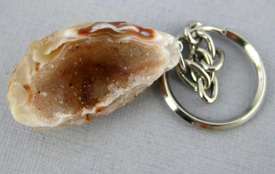 Close up of one agate Geode Keychain on a light colored background.