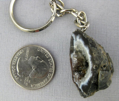 One agate geode keychain next to a quarter for size reference.