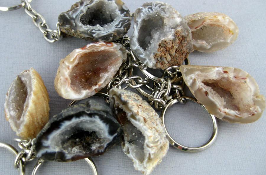 Multiple agate geode keychains displaying color, shape, pattern varieties on a light colored background.