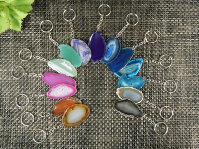 Multiple agate keychains on a dark colored background