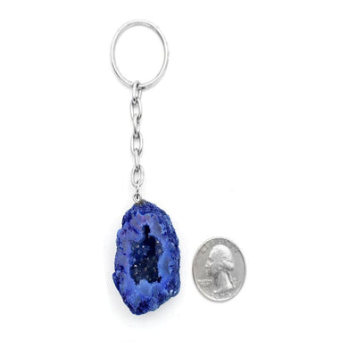 colored half occo geode silver toned keychain pictured next to a quarter for size reference