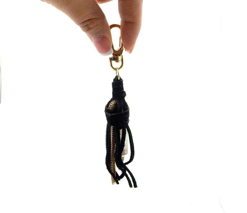 hand holding up lack Leather Keychain with Crystal Quartz Point on white background